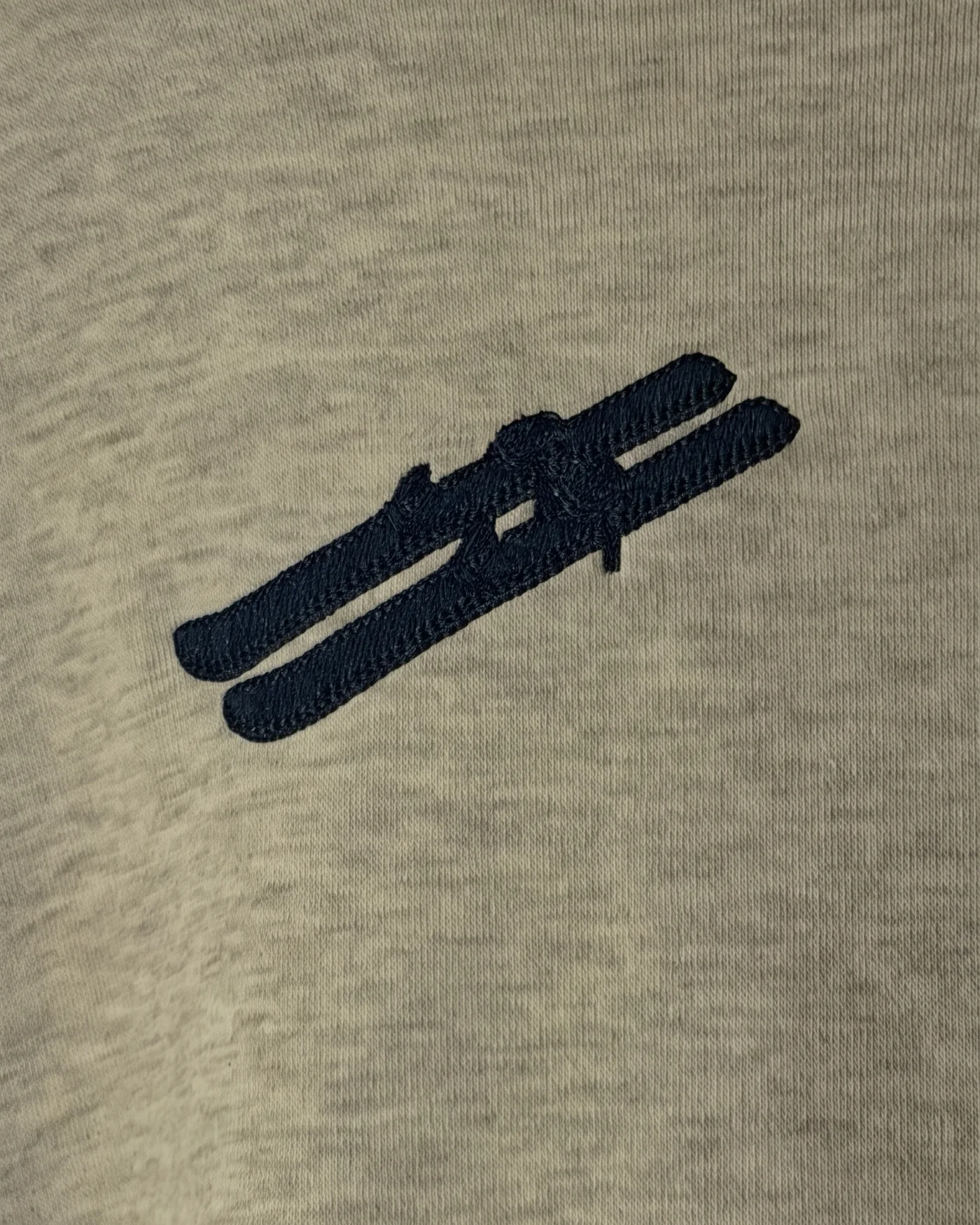 Navy chain-stitch emblem on heather grey fleece